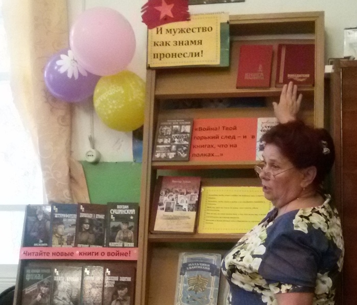 С обзором книжной выставки выступает библиотекарь Нижнетоемской библиотеки В. В. Половенская